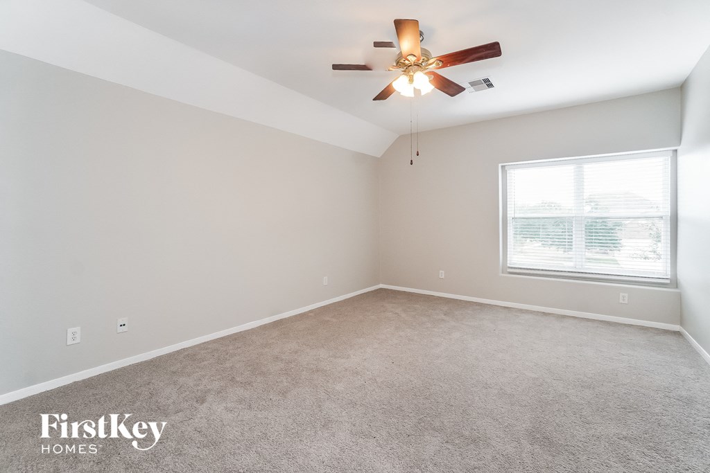 a bedroom with a ceiling fan and a window