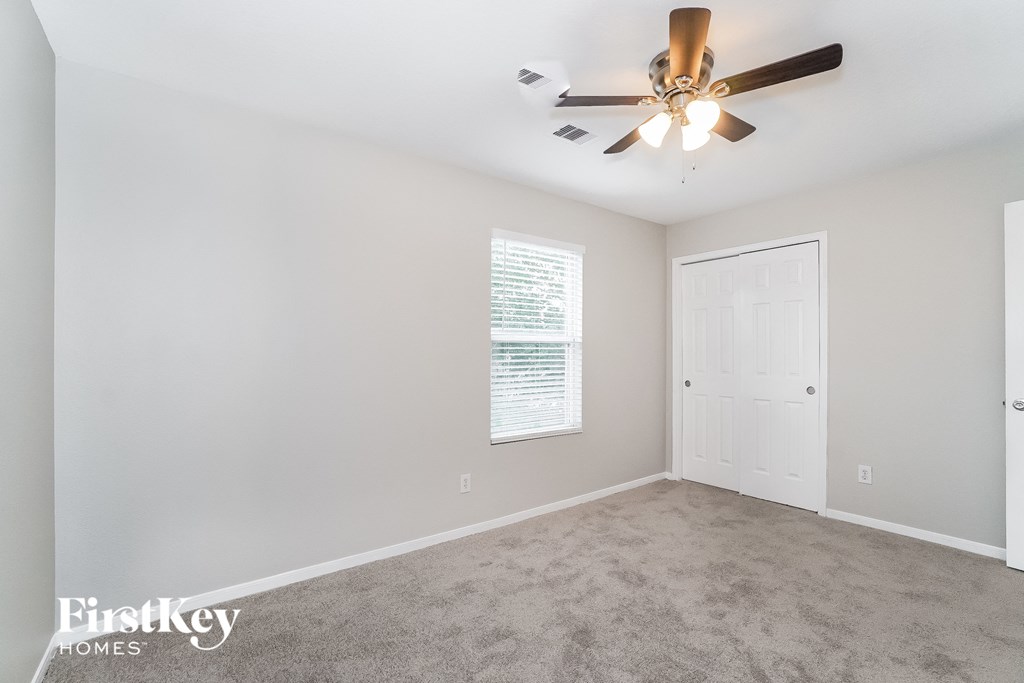 a living room with carpet and a ceiling fan