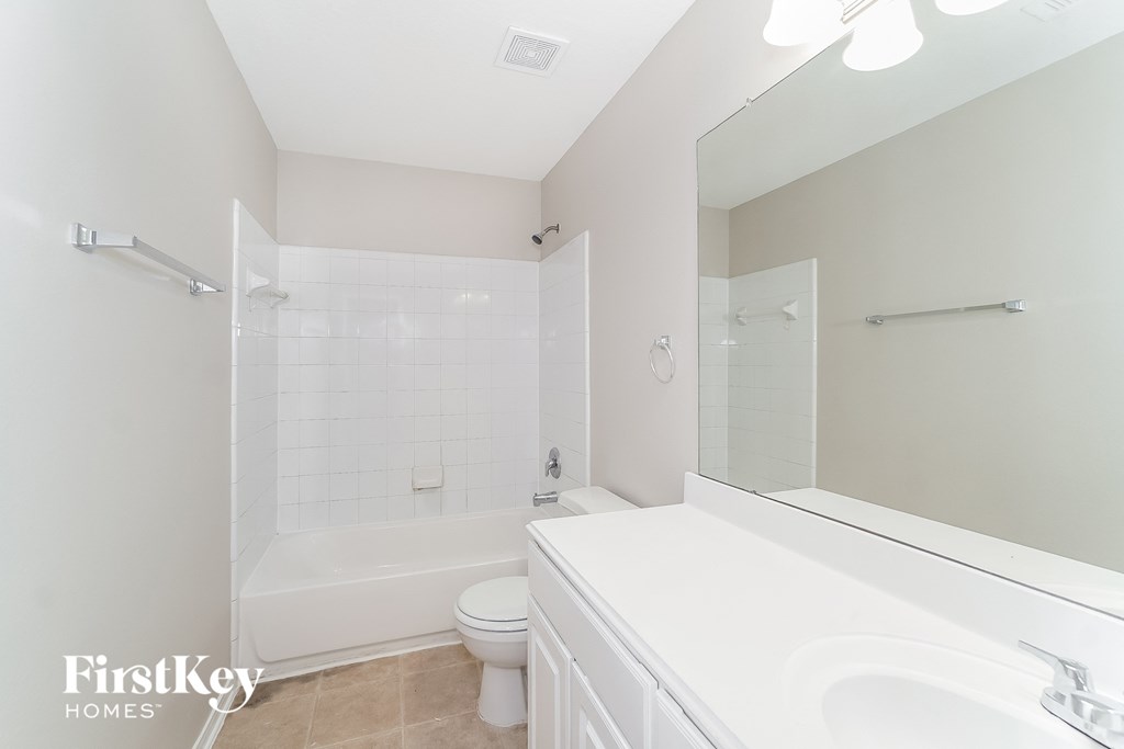 a white bathroom with a tub and a sink and a toilet