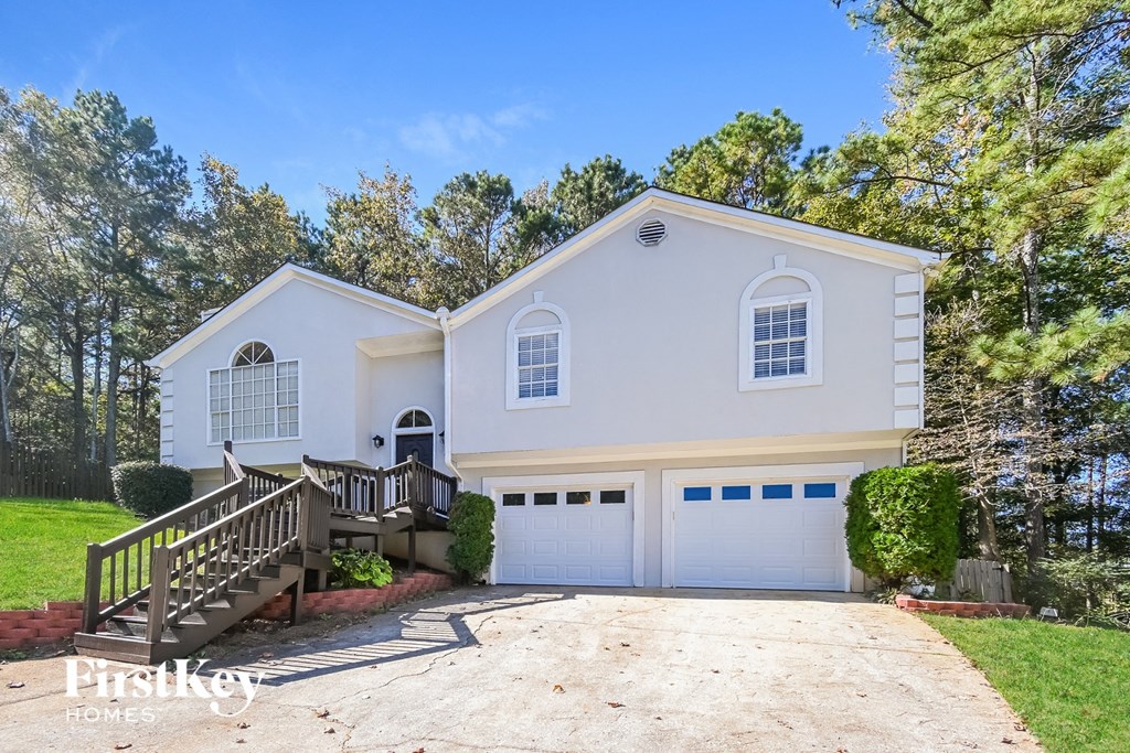 a white house with a driveway and a white garage door