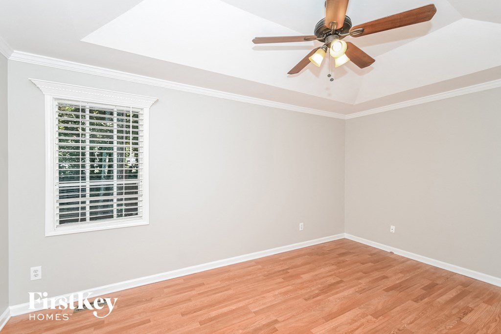 a living room with wood floors and a ceiling fan