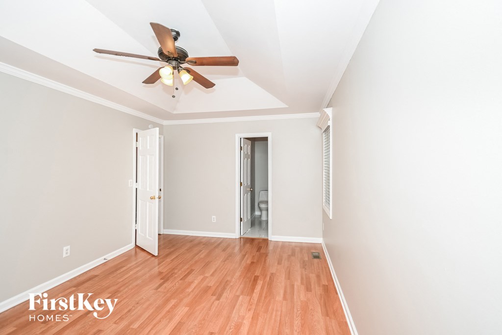 a living room with wood floors and a ceiling fan