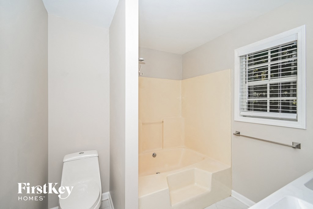 two views of a bathroom with a toilet and a bath tub