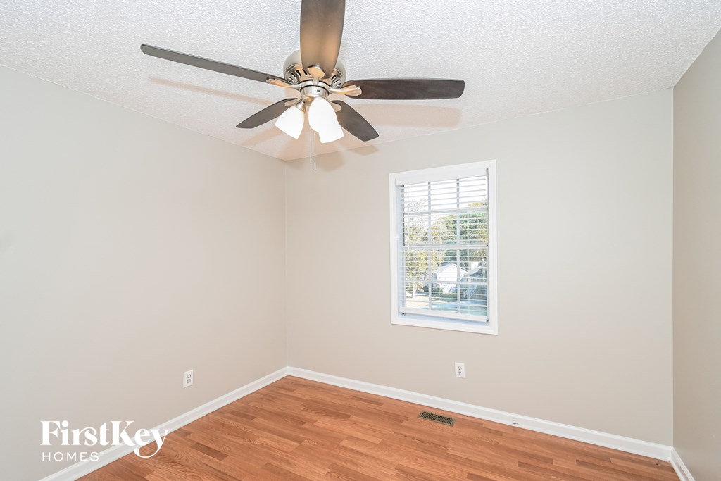 a living room with a ceiling fan and a window