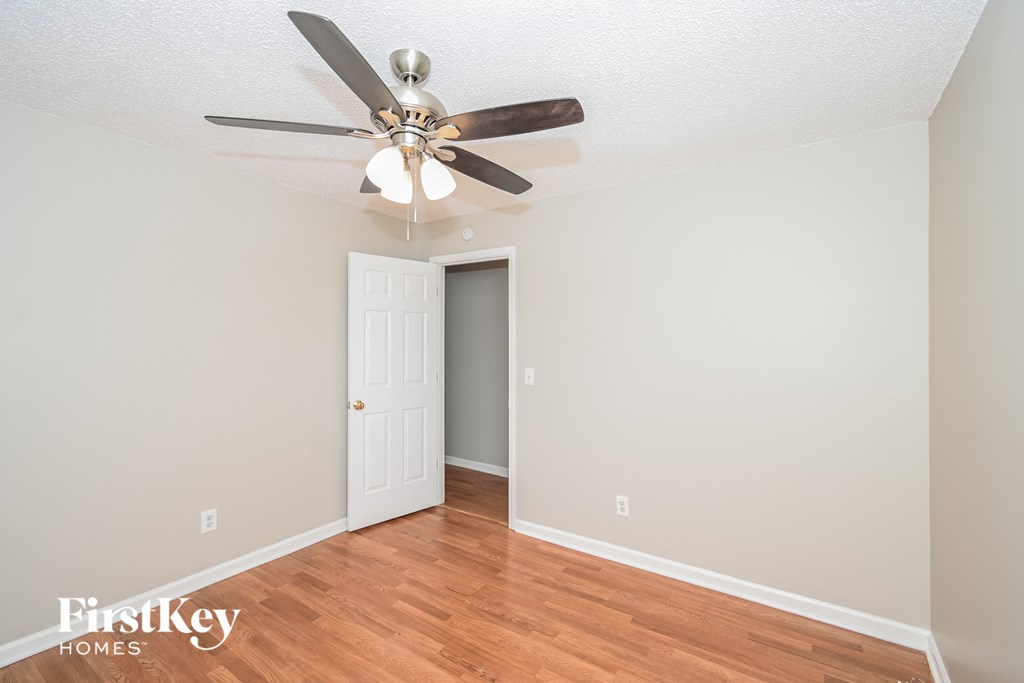 a living room with a ceiling fan and a door to a closet