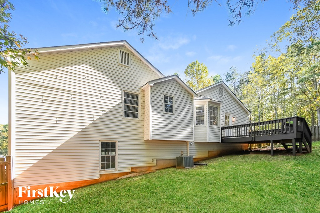 the back of a house with a deck and a large yard