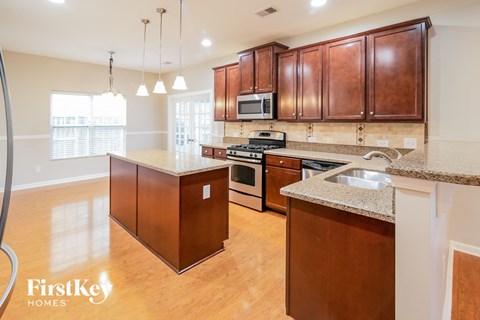 A kitchen with wooden cabinets and a granite countertop.