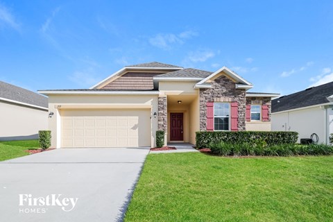 A house with a garage and a driveway in front of it.