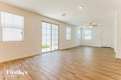 an empty living room with wood flooring and a window