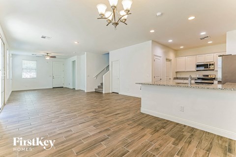 an open kitchen and living room with a counter top and a kitchen island