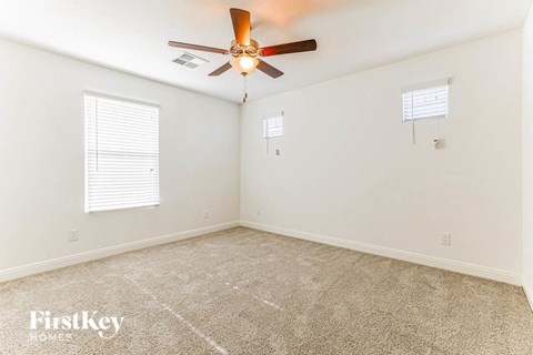 a bedroom with a ceiling fan and a carpeted floor