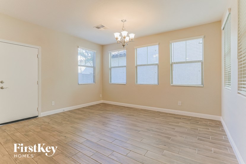 the living room of a home with a wooden floor and windows