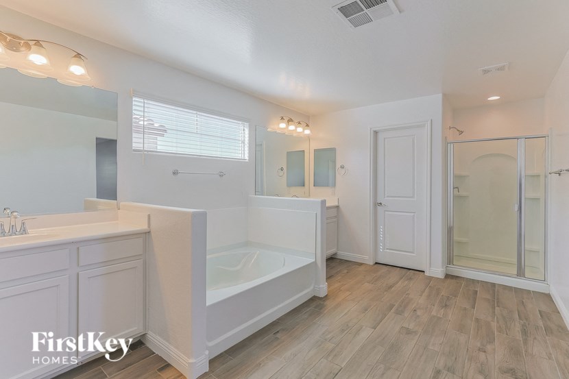 a white bathroom with a tub and a sink and a shower