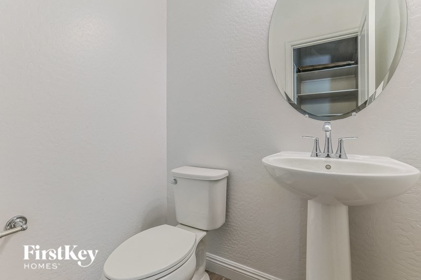 a white bathroom with a sink toilet and a mirror