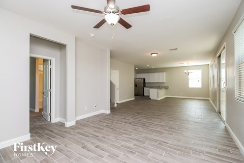 A spacious room with a ceiling fan and light fixture.