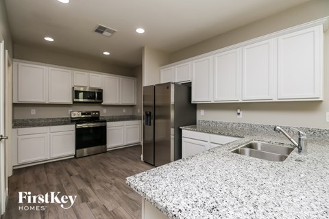 A kitchen with granite countertops and stainless steel appliances.