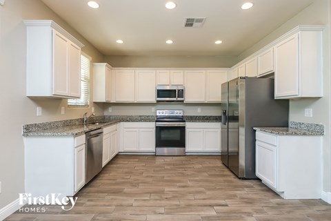 a kitchen with white cabinets and stainless steel appliances