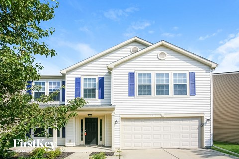 a white house with blue shutters and a garage door