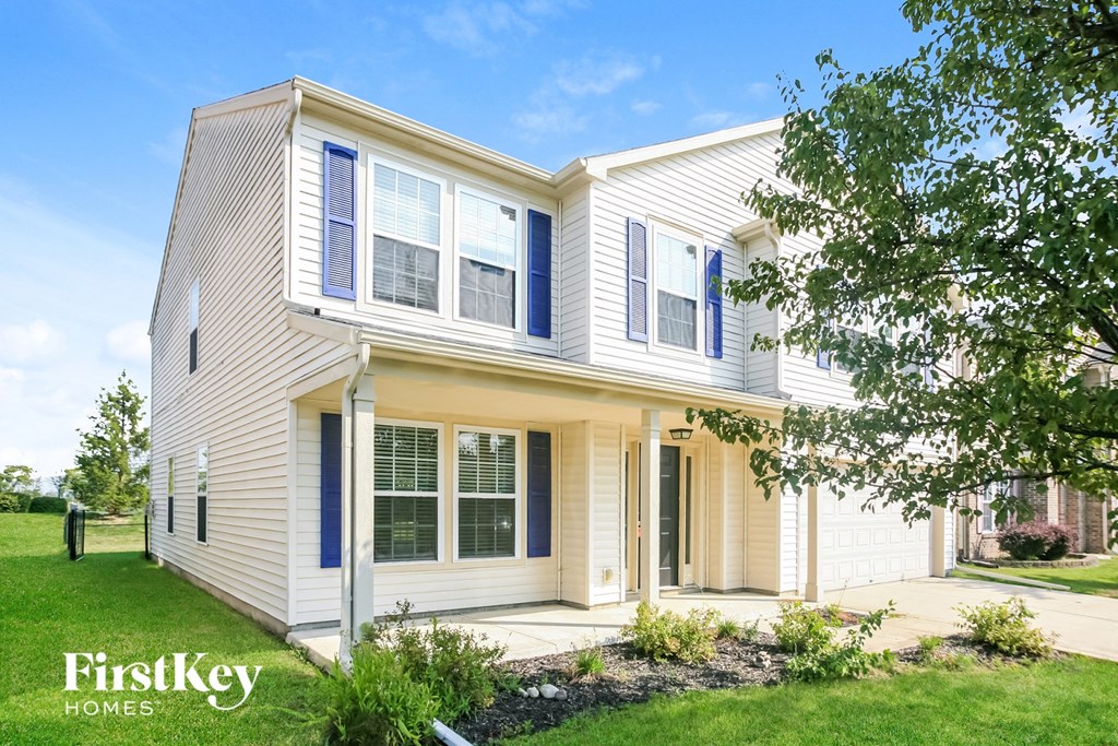 a white house with blue shutters and a lawn