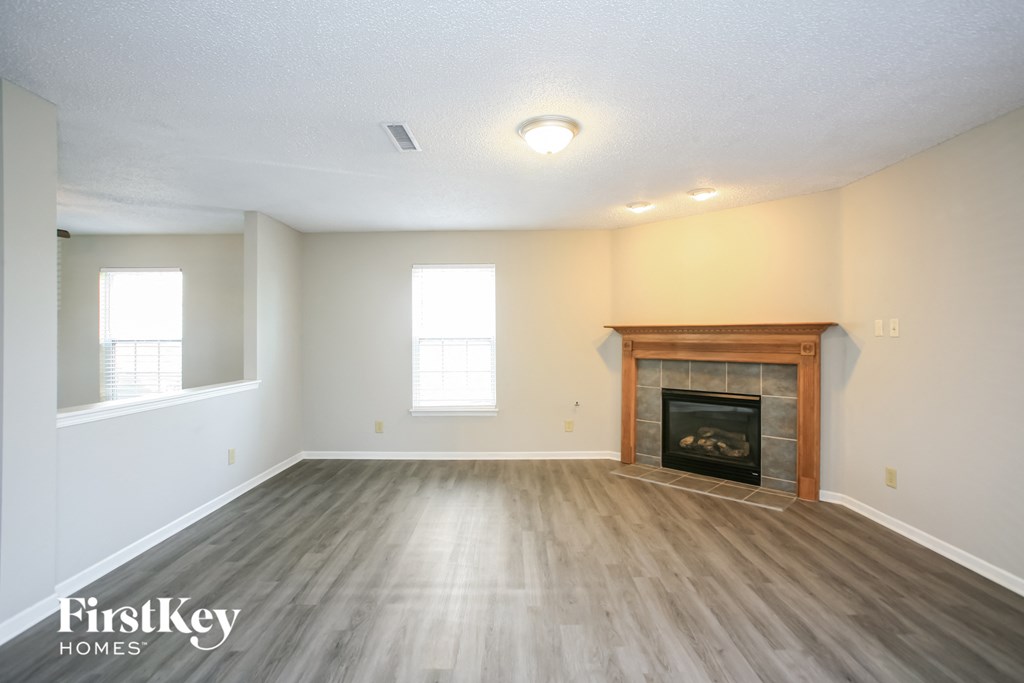 the living room with wood flooring and a fireplace