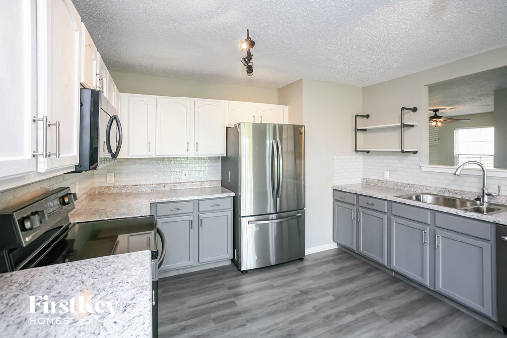 a kitchen with stainless steel appliances and white cabinets
