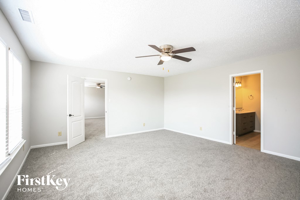 an empty living room with a ceiling fan