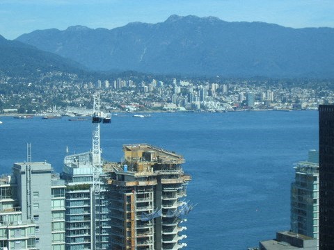 a view of a city and the ocean and mountains