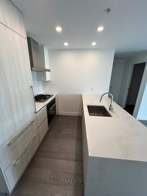 A modern kitchen with white cabinets and a marble countertop.