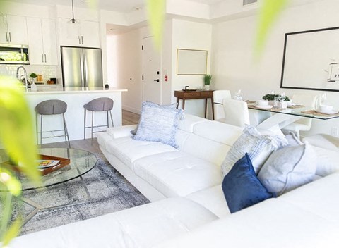 a living room with a white couch and a glass table