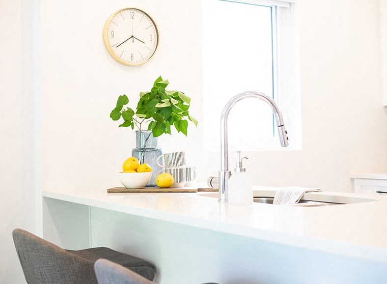 a kitchen with a sink and a clock on the wall
