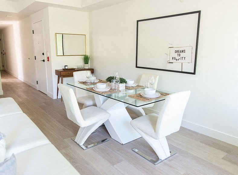 a dining room with a glass table and white chairs