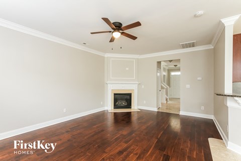 A spacious room with a fireplace and a ceiling fan.