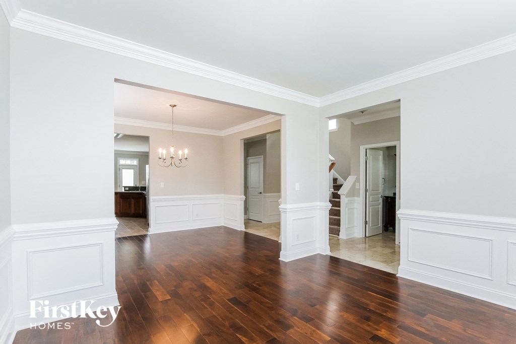 A large empty room with wooden floors and white walls.