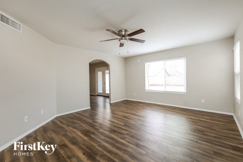 a living room with hardwood floors and a ceiling fan