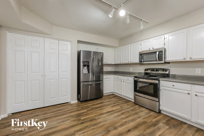 a kitchen with white cabinets and stainless steel appliances