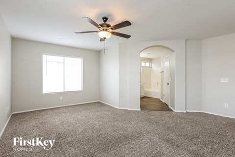a living room with carpet and a ceiling fan