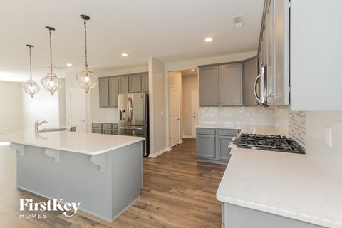a white kitchen with gray cabinets and white counter tops