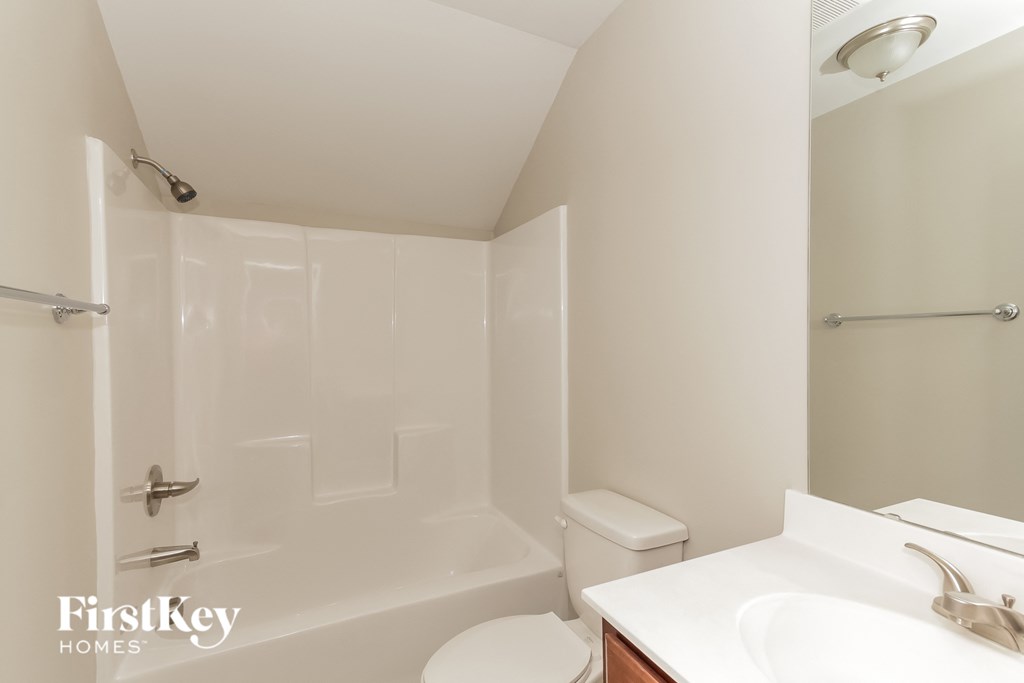 a bathroom with a toilet and a sink and a bath tub