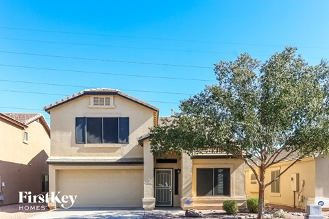 a beige house with a tree in front of it