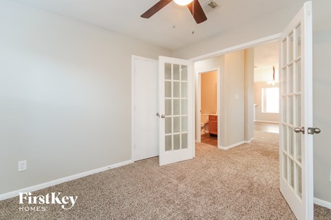 a bedroom with a ceiling fan and a door to a closet