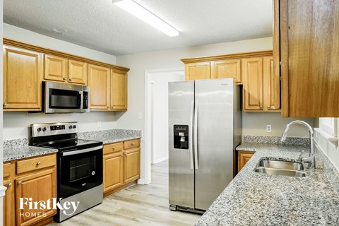 A kitchen with wooden cabinets and a stainless steel refrigerator.