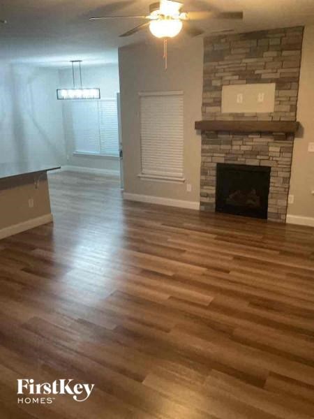 A living room with a fireplace and wood flooring.