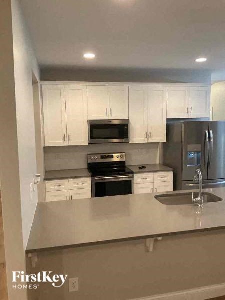 A kitchen with white cabinets and stainless steel appliances.