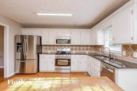 a kitchen with white cabinets and stainless steel appliances