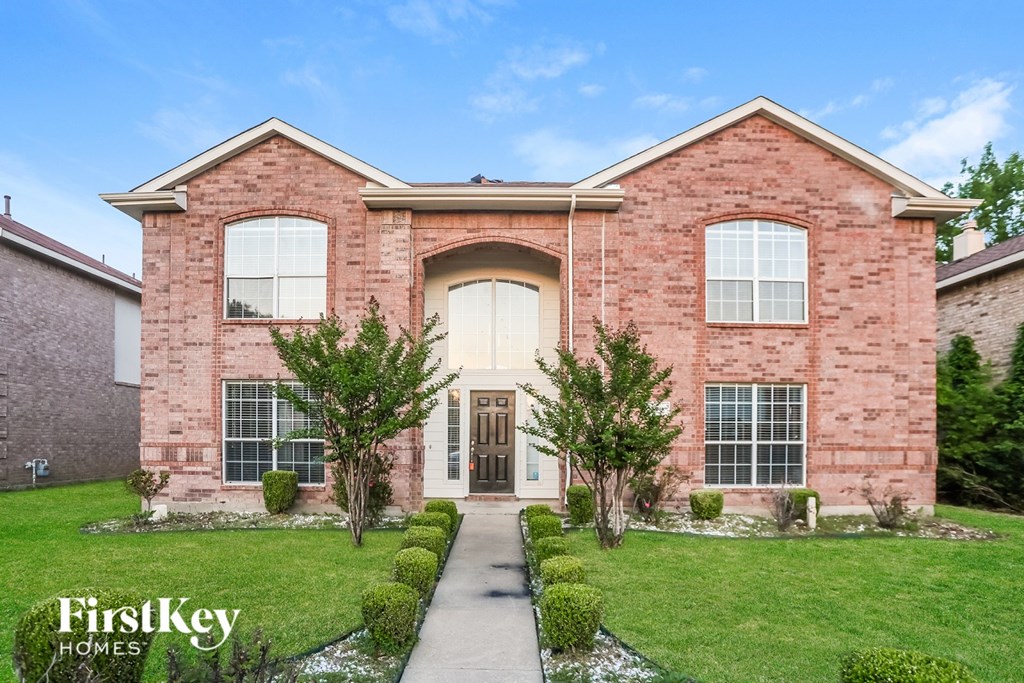 A brick house with a white door and windows.