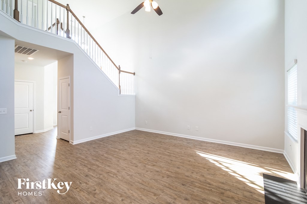 an empty living room with white walls and a wooden floor