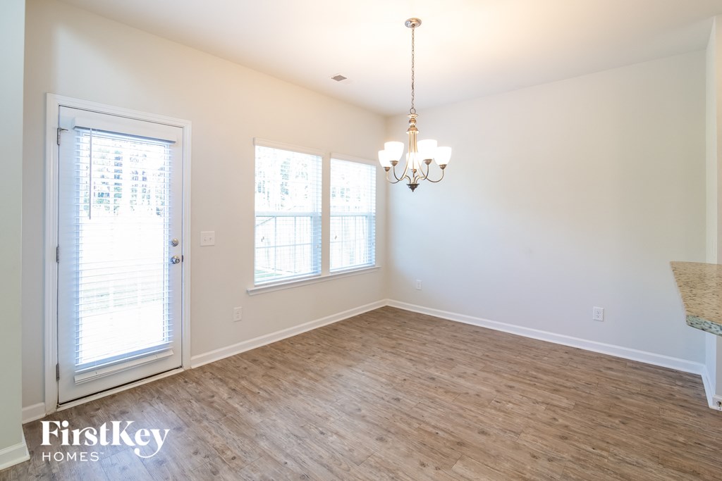 a living room with a wood floor and a chandelier