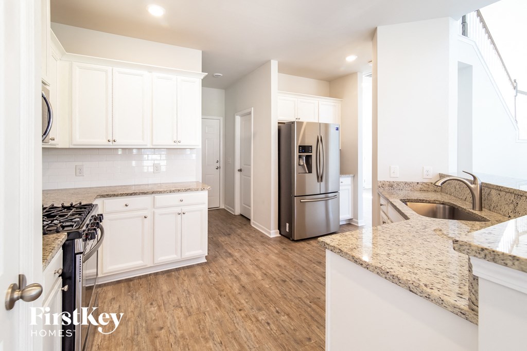 a kitchen with white cabinets and a stainless steel refrigerator