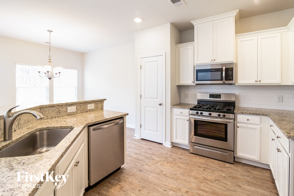 a kitchen with white cabinets and stainless steel appliances