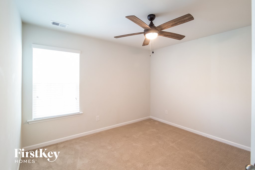 a bedroom with a ceiling fan and a window